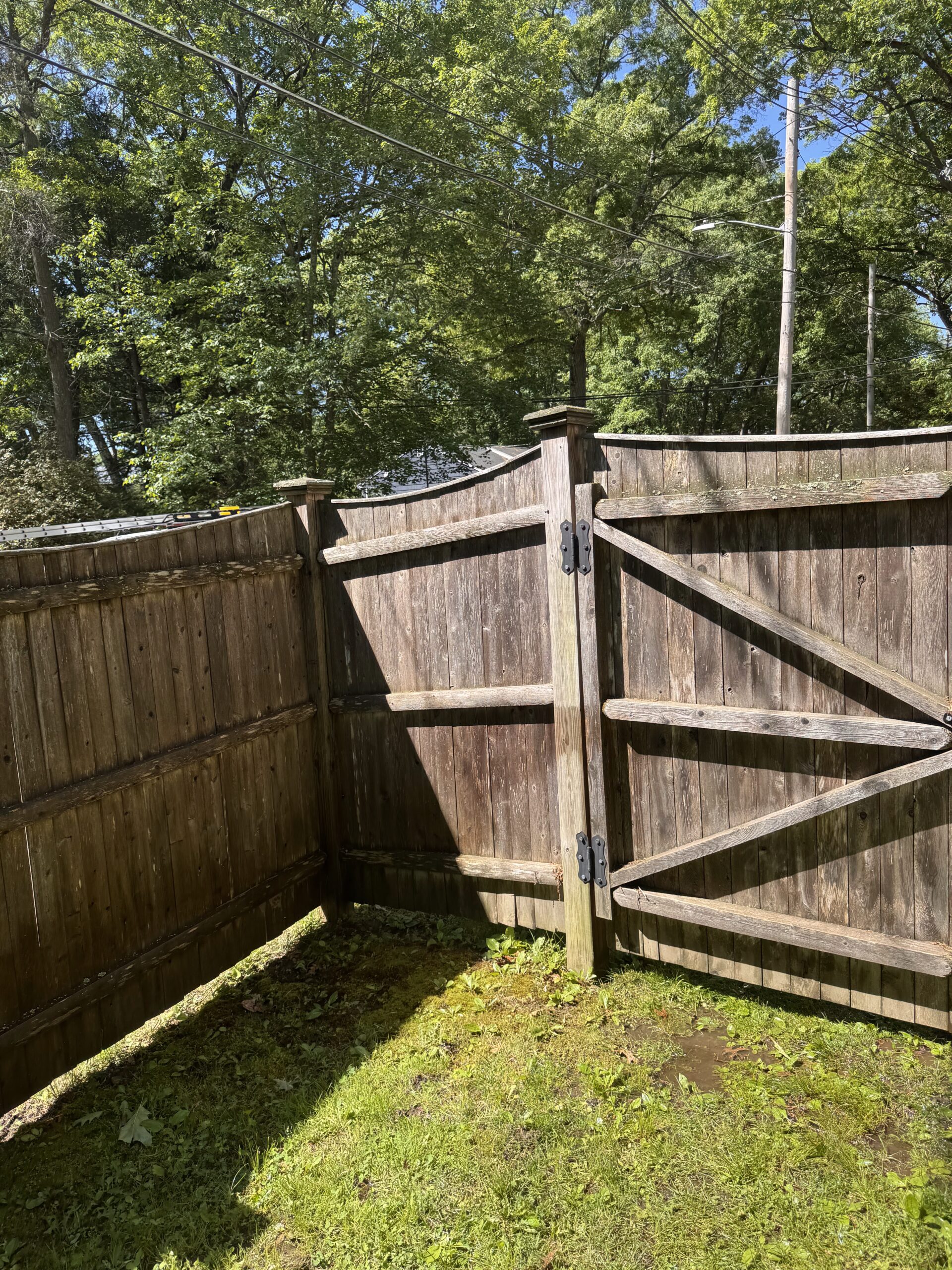 Pressure washing fence before treatment in Needham, MA