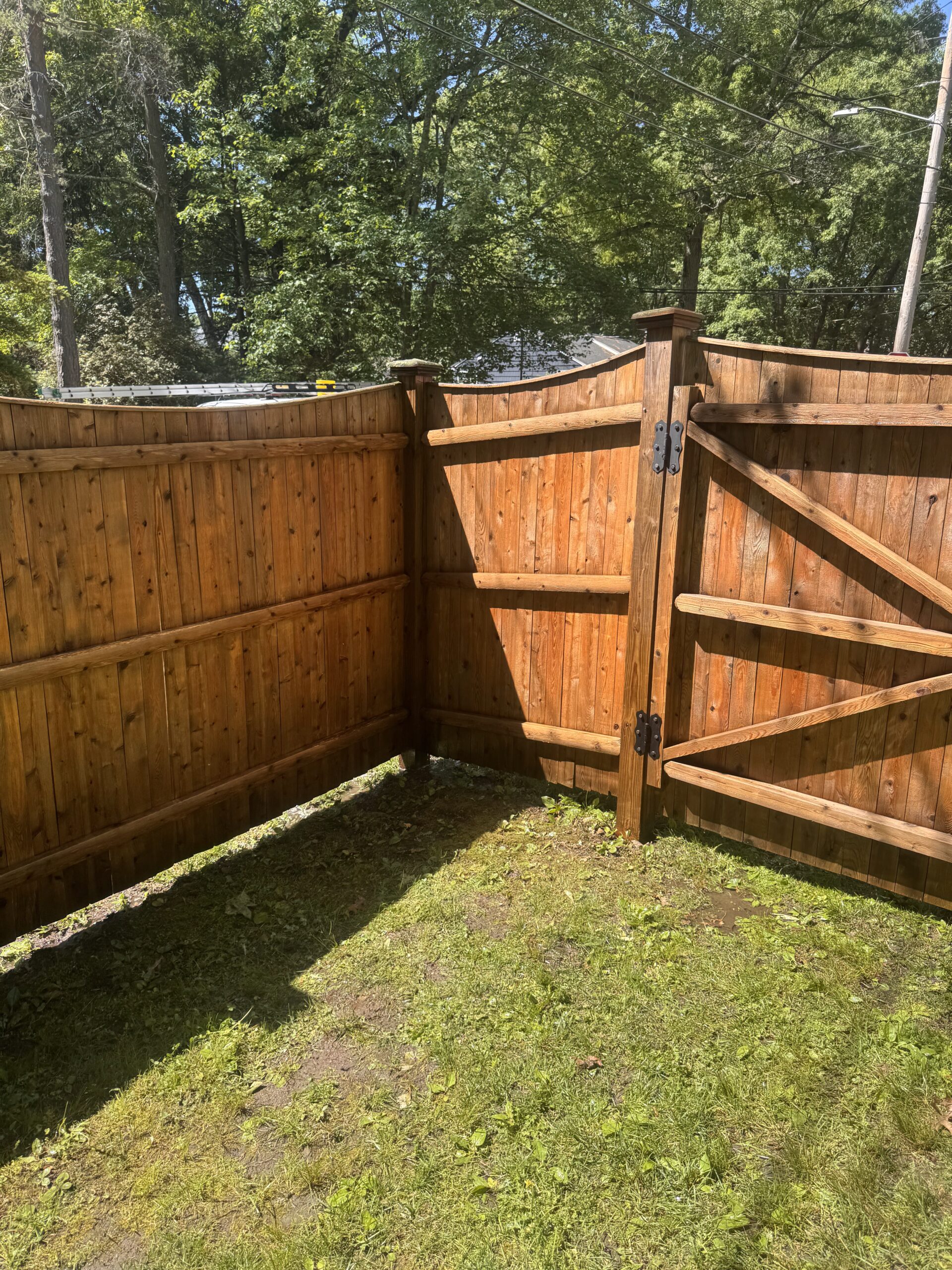 Pressure washing fence after treatment in Needham, MA